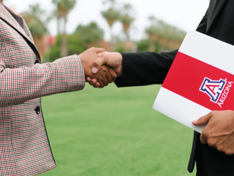 Two professionals shaking hands on the UArizona campus