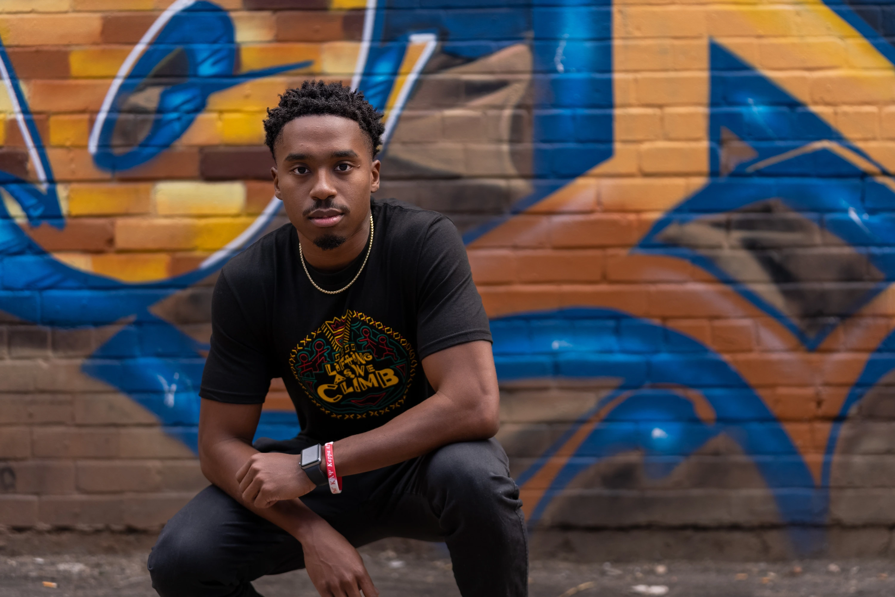 UArizona student in front of graffiti wall