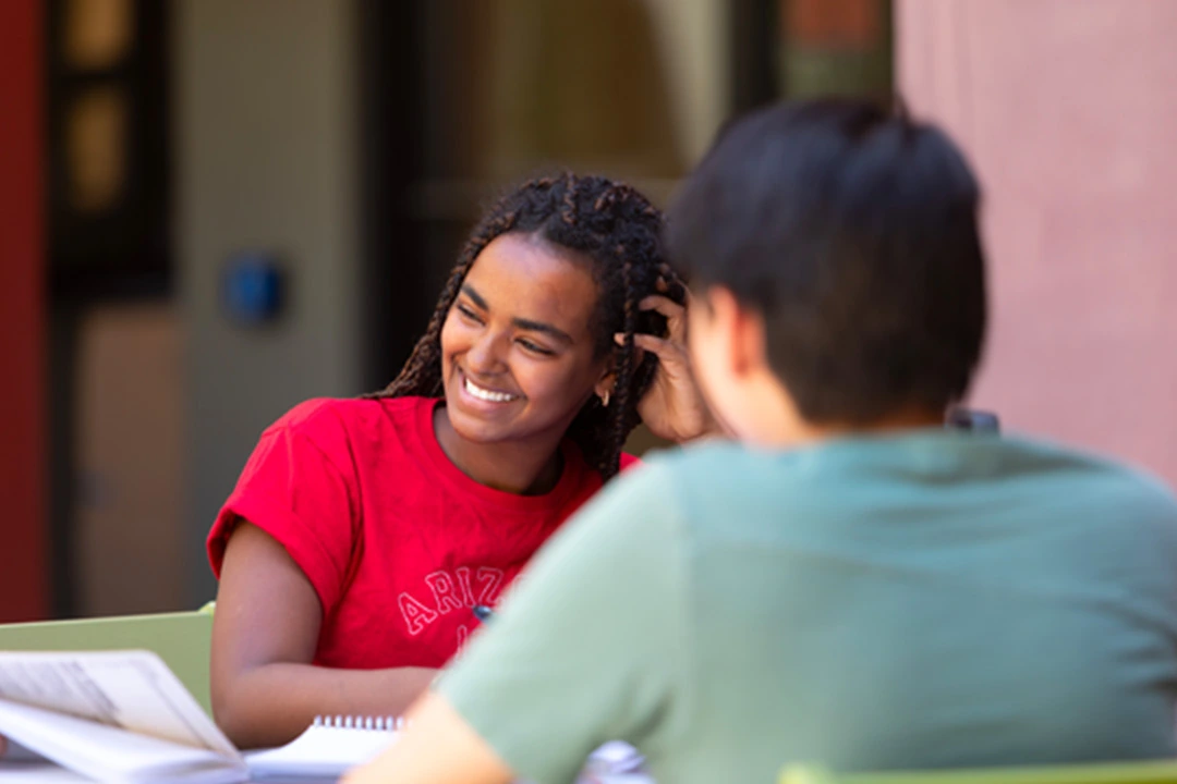 Woman and fellow student laughing while studying